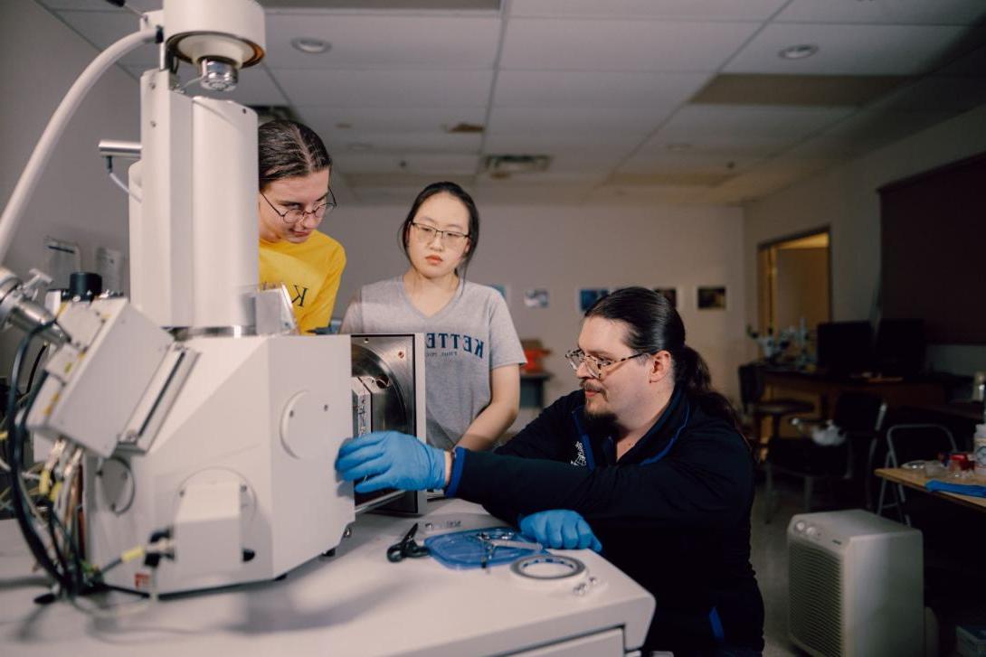 A Kettering professor and two students use an electron microscope